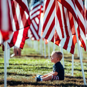 Cody Harter, 2, of Murrieta, sits between rows of American Flags while visiting Field of Honor at Town Square Park in Murrieta on Tuesday, Nov. 12, 2019. (Photo by Watchara Phomicinda, The Press-Enterprise/SCNG)