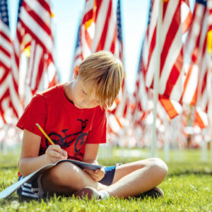 Brody Heiden, 10, a 5th grade student from Paloma Elementary School, writes down information during a field trip to the Field of Honor at Town Square Park in Murrieta on Tuesday, Nov. 12, 2019. (Photo by Watchara Phomicinda, The Press-Enterprise/SCNG)
