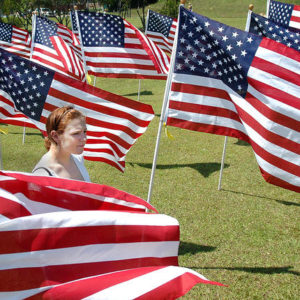 1st Lt. Jenna Grassbaugh searches for the flag in honor of her husband, Capt, Jonathan Grassbaugh, during the opening dedication ceremony Saturday of the Field of Honor. Jonathan Grassbaugh was killed in Iraq in April 2007.