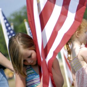 100515-A-6312K-175 FAYETTEVILLE, N.C. ó Ashlyn Rodgers, 5, embraced the flag placed in honor of her deceased father during the opening ceremony at this yearís Glory Days Field of Honor outside the grounds of the Airborne and Special Operations Museum Saturday in Fayetteville. Both Ashlyn and her sister Autumn, 6, placed their sandals next to their dadís flag so when they walked away they knew exactly where his flag was dancing through the air. (U.S. Army Photo by Cpl. Jessica M. Kuhn, 49th Public Affairs Detachment (Airborne))