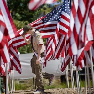 Honor scout Blake Stevenson with the Order of the Arrow walks among the flags in the Field of Honor in Los Rios Park in San Juan Capistrano. Scouts with the order were helping to place the flags for Memorial Day.

 ///ADDITIONAL INFO: 0526.sjc.honor - 5/21/16 - Photo by PAUL RODRIGUEZ - Honor scouts from the Order of the Arrow help place 300 large flags for a Field of Honor at Los Rios Park in San Juan Capistrano. The event is organized by Homefront America which will conduct a Memorial Day ceremony at the park.