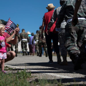 Mike Hopwood, of Los Alamos, and his 3-year-old daughter, Lainey Hopwood, cheer the Memorial Day Flag March on Monday (May 28) at the Vietnam Veterans Memorial in Angel Fire.