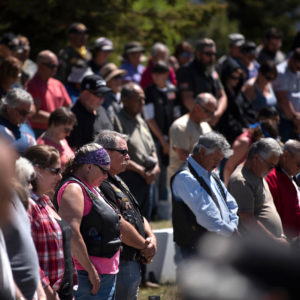 Mourners bow their heads in a moment of silence Monday (May 28) during the 2018 Memorial Day Ceremony at the Vietnam Veterans Memorial in Angel Fire.