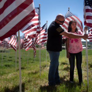 Richard Vialpando, of Questa, and his 10-year-old daughter, Cieara Vialpando, pay their respects to the late Henry Cisneros at Taos CountyÕs 13th Annual Field of Honor flag display in Questa. Cisneros was killed in World War II.